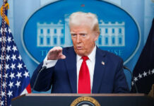 Person speaking at podium in press conference room