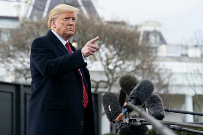 2600426001 Man gesturing near microphones outside a building