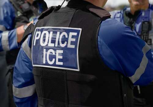 shutterstock_2615419741 (10).jpg Close-up of a police officer's uniform with 'POLICE ICE' on the back