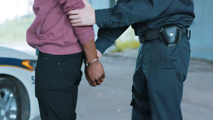 1644827041 Police officer arresting a person outdoors