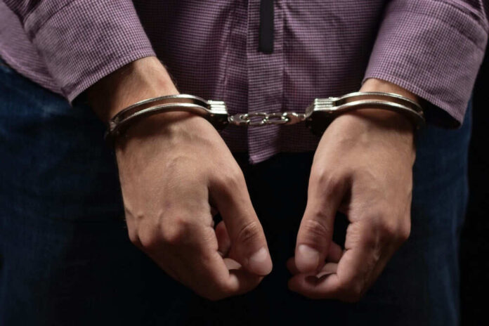 Person wearing handcuffs in front of body