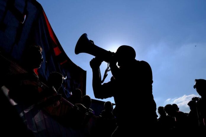 Silhouette of a person using a megaphone during a protest