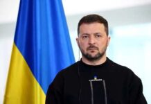 A political leader standing in front of a Ukrainian flag during a press conference