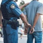 28-Year-Old Murder Case Solved Thanks to Advanced Forensics Police officer handcuffing a suspect in a street setting