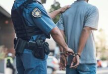 Police officer handcuffing a suspect in a street setting