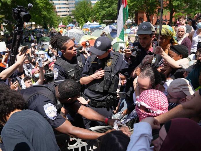 shutterstock_2457054175.jpg Police officers interacting with a crowd during a protest