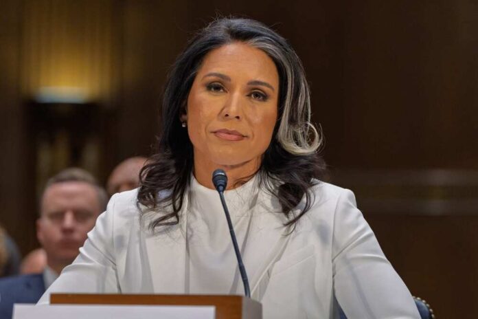 A woman in formal attire seated at a hearing, looking serious