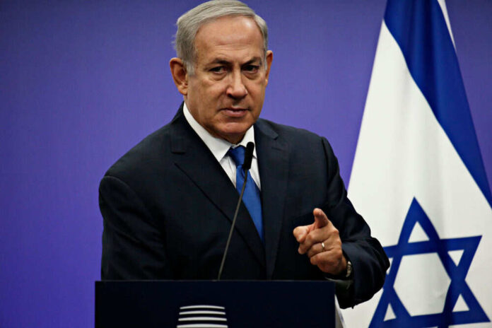 Man speaking at podium with Israeli flag background
