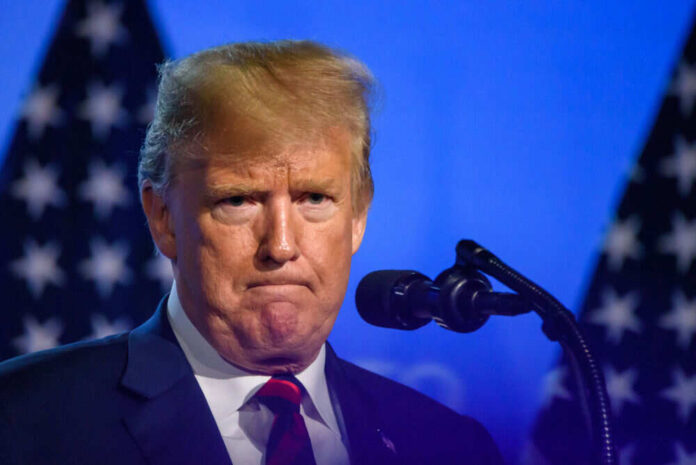 1133547368 Man speaking at a podium with flag background