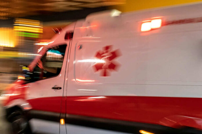 Fastmoving ambulance with flashing lights at night