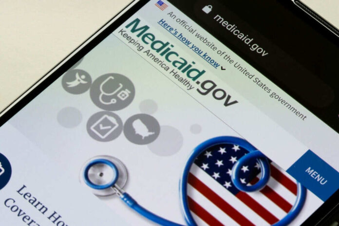 2082926293 Medicaid website on phone screen with stethoscope graphic