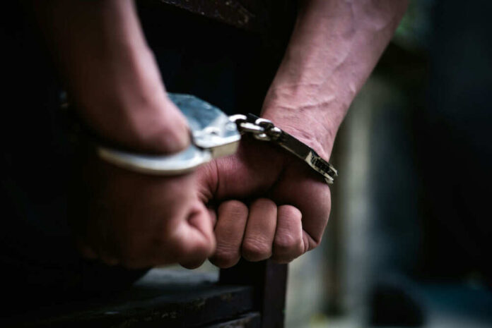 Hands in handcuffs behind the back tightly secured