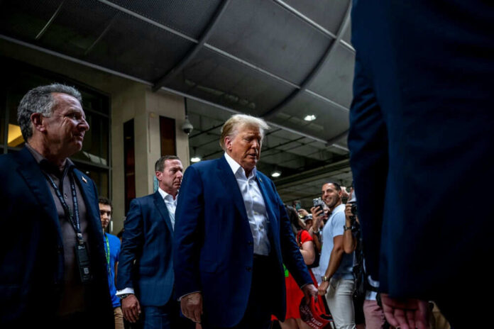 Man walking through crowd indoors with people around