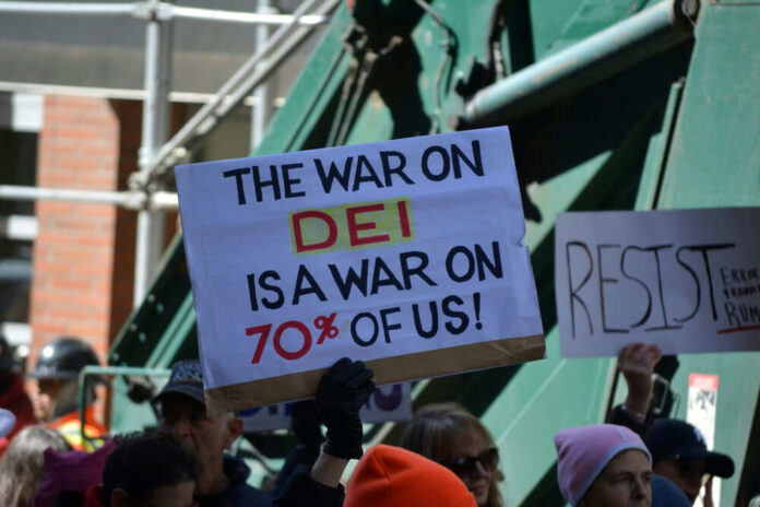 Protesters holding signs including The War on DEI