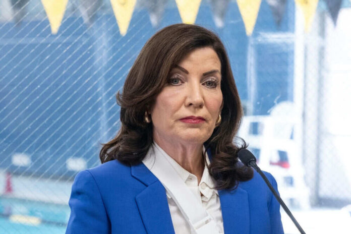 Woman in blue blazer speaking into microphone