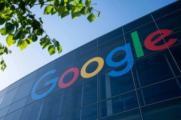 Google logo on glass building exterior with leaves