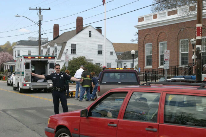 Police officer directing traffic near ambulance scene