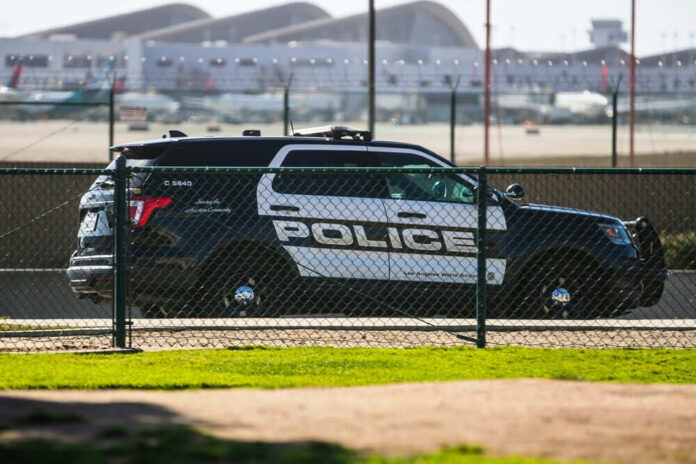 Police car parked near airport runway fence