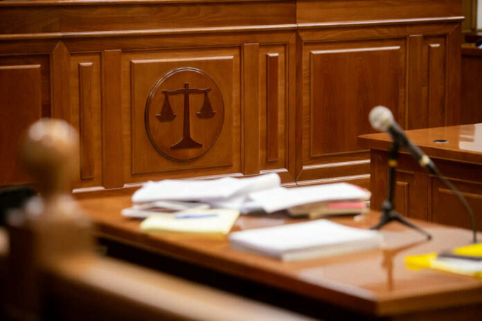 Courtroom desk with papers and microphone visible