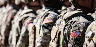 Military personnel in camouflage uniforms standing in line