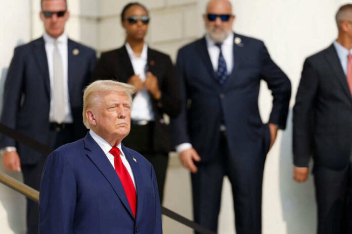 Man in blue suit with people in background standing