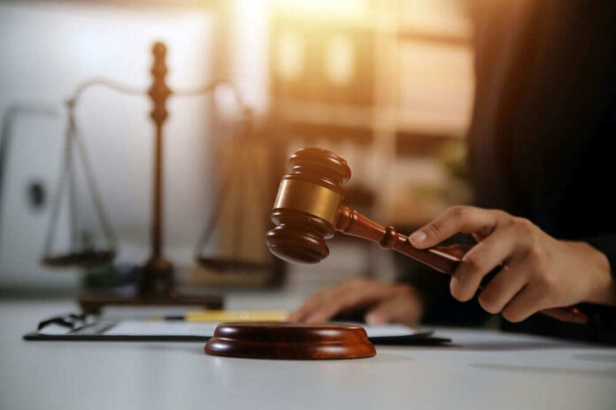 Gavel in hand near scales of justice