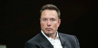 Man in suit sitting with serious expression