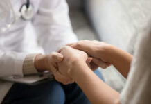 Doctor holding patients hands comforting them